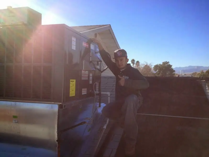 HVAC technician performing HVAC Inspection on a rooftop unit in Roxbury
